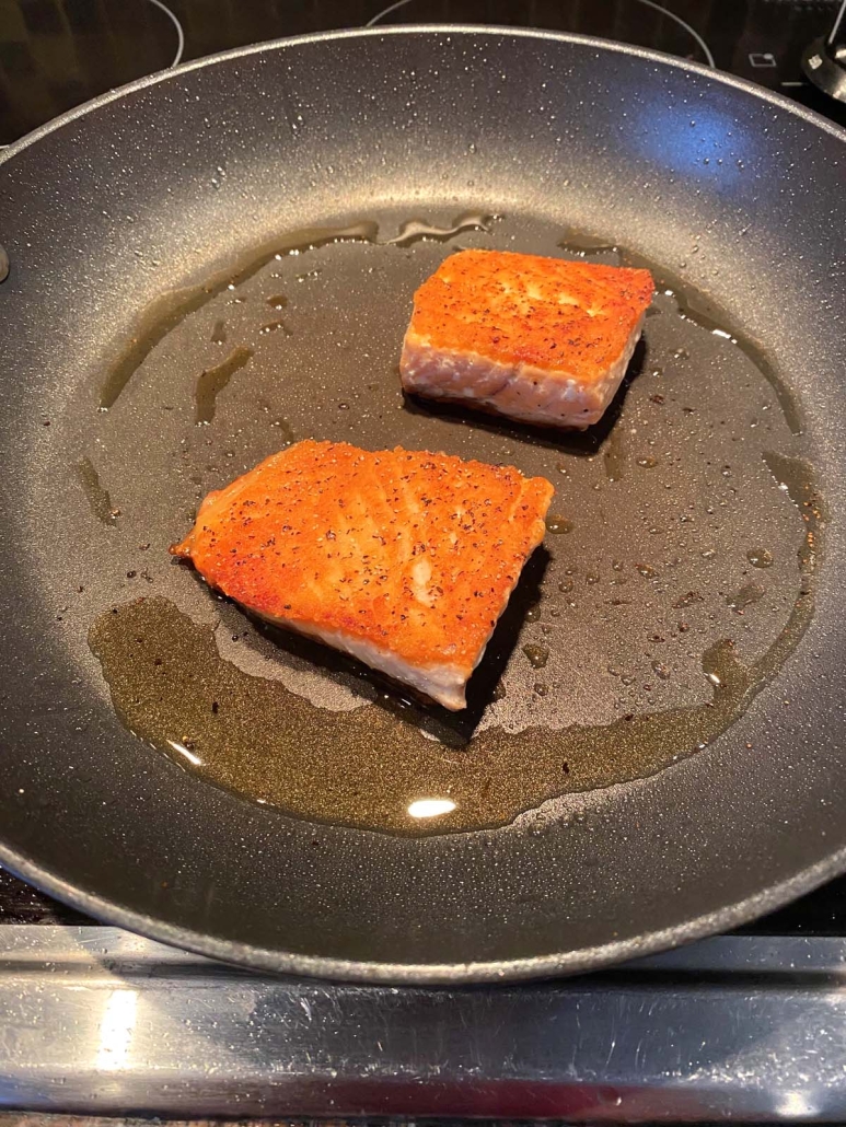 fresh salmon fillets in a skillet