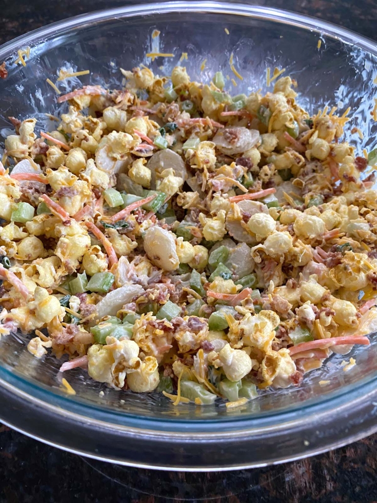 ingredients for popcorn salad mixed up in a bowl
