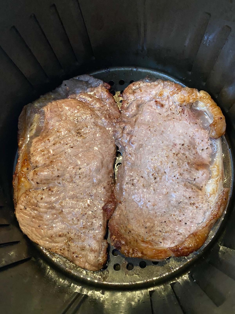close-up of seasoned steaks in air fryer