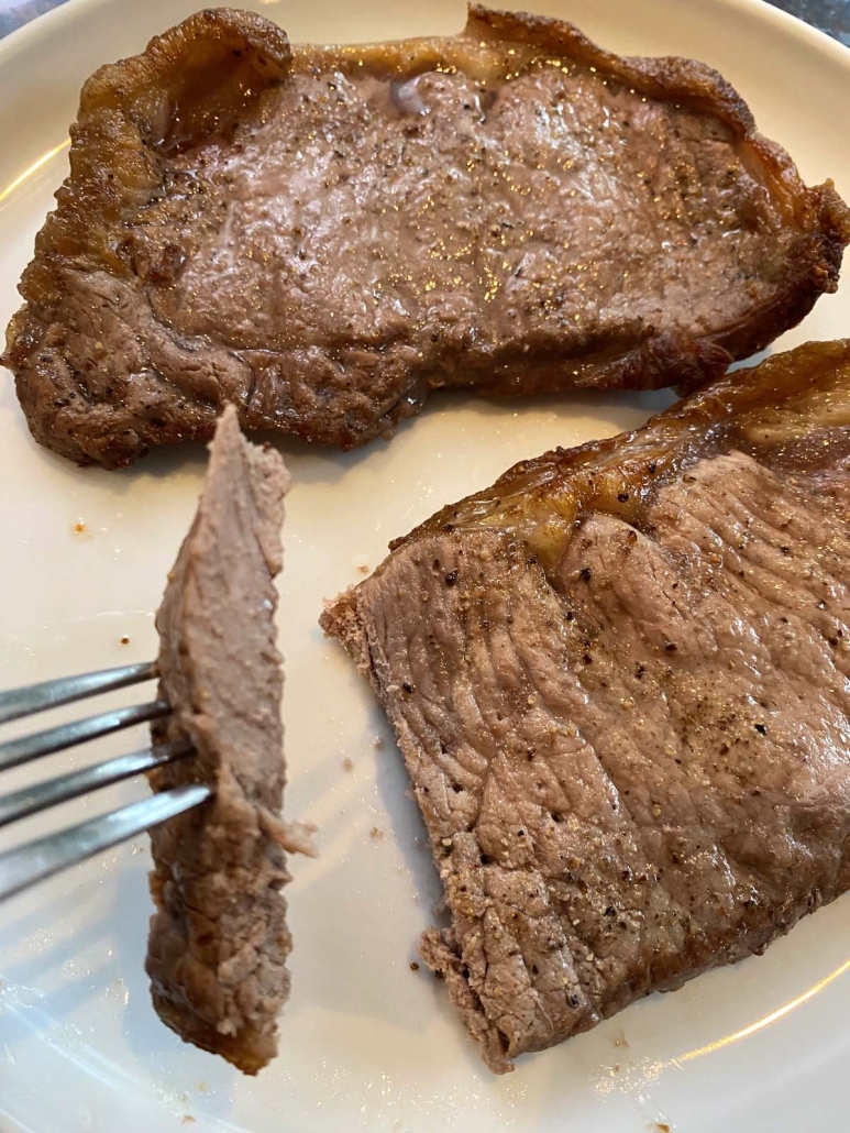 fork holding piece of New York strip steak