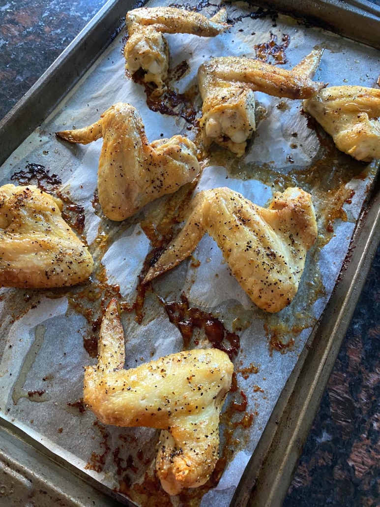seasoned chicken wings on a baking sheet