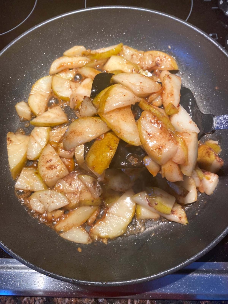 spatula mixing sliced pears in seasonings