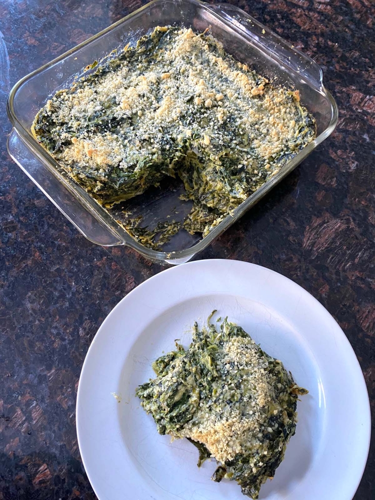 easy, cheesy Spinach Casserole on a plate next to a casserole dish