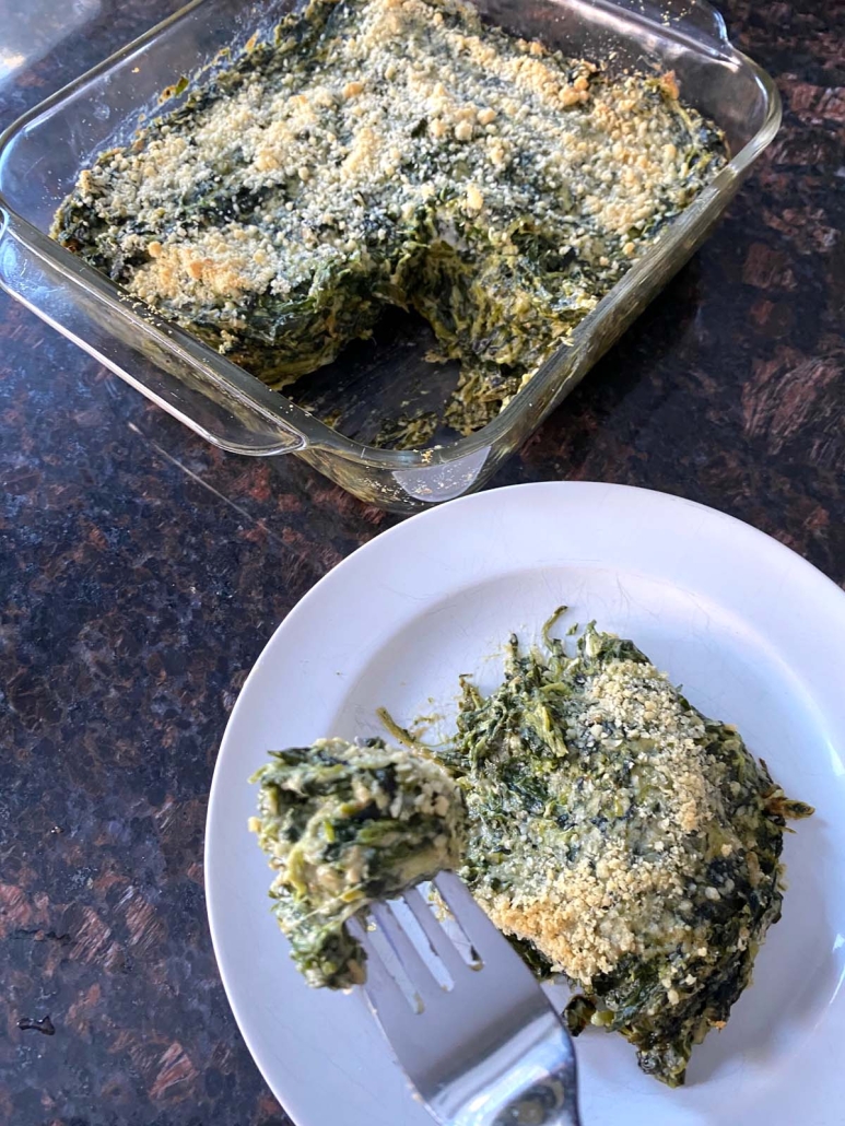 slice of Spinach Casserole next to baking dish