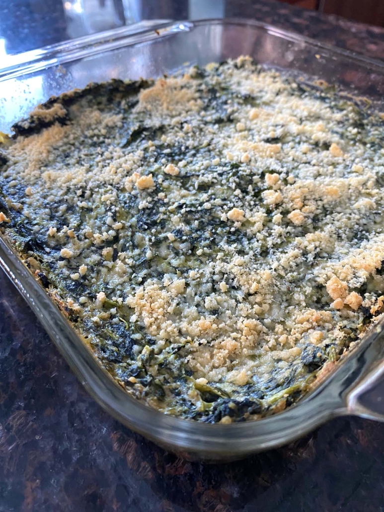 corner of cheesy Spinach Casserole in baking dish