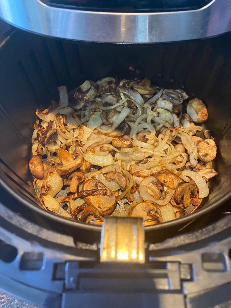 air fryer opened to show cooked Mushrooms And Onions