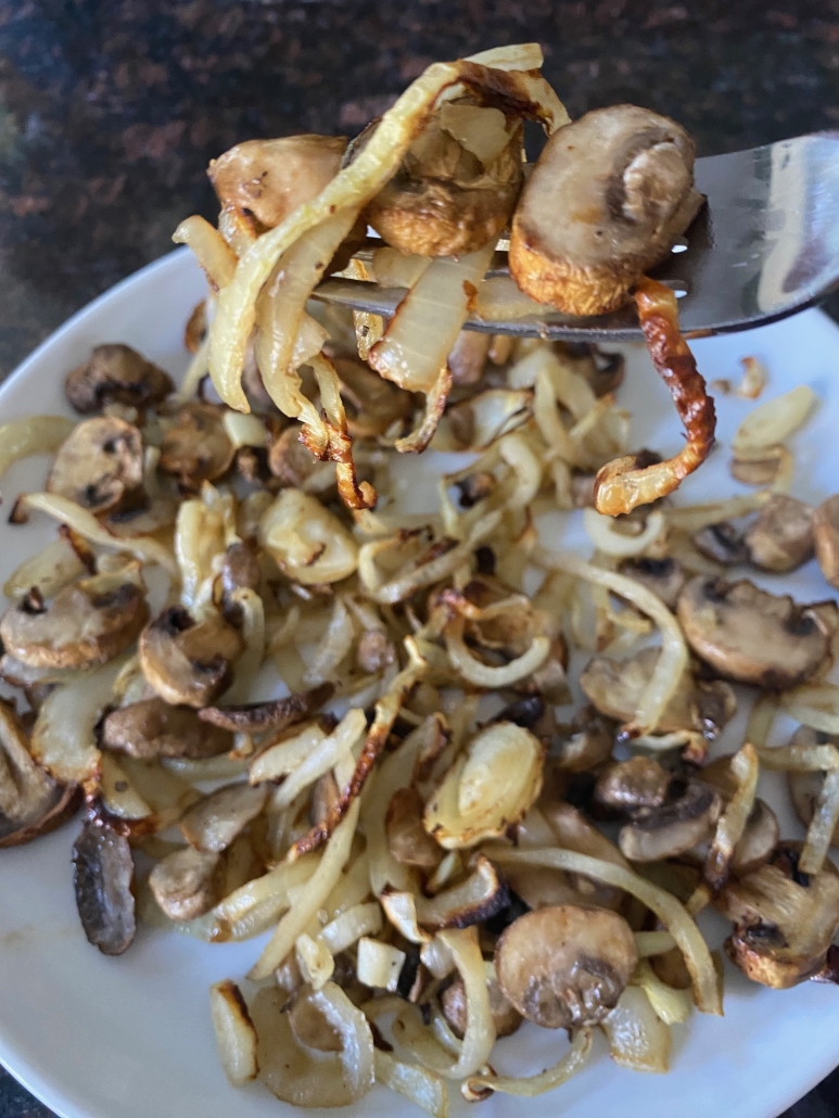 fork in portion of Air Fryer Mushrooms And Onions