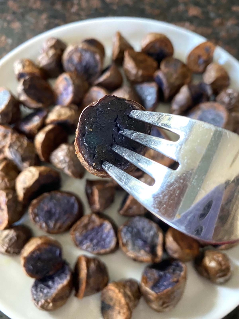 fork holding piece of Purple Potatoes Cooked In Air Fryer