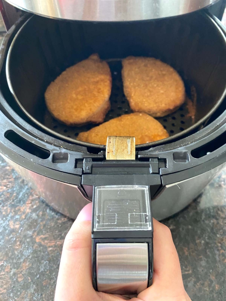 opening air fryer to show Shake N Bake pork chops