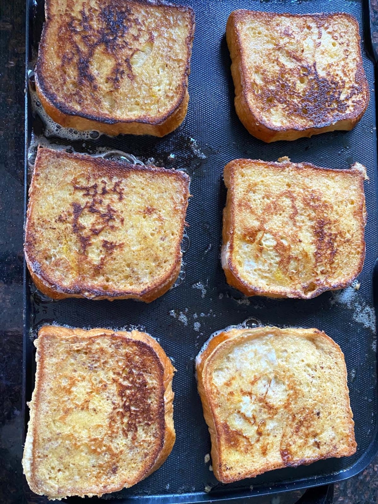 brioche french toast cooking on a griddle