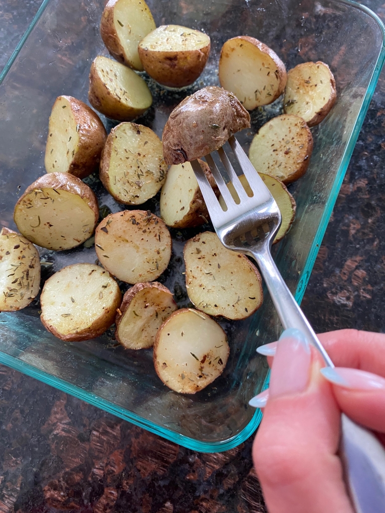 fork holding piece of microwaved red potato