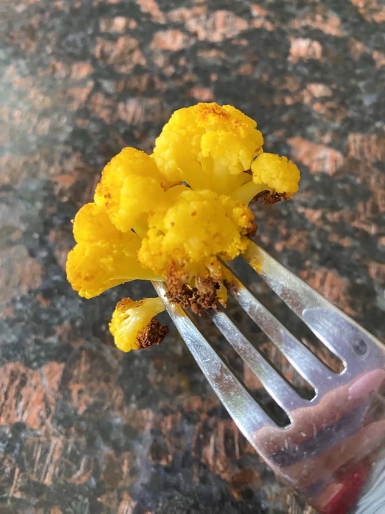fork holding orange cauliflower floret