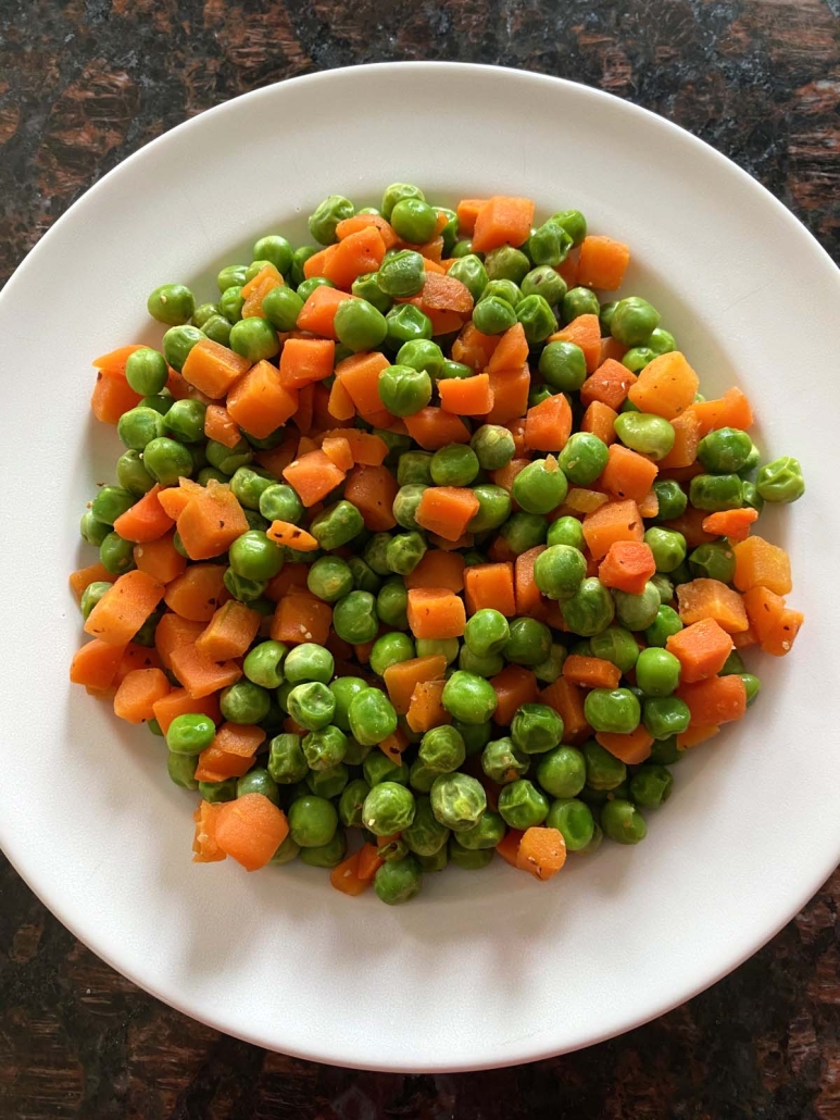 serving plate with peas and carrots on top