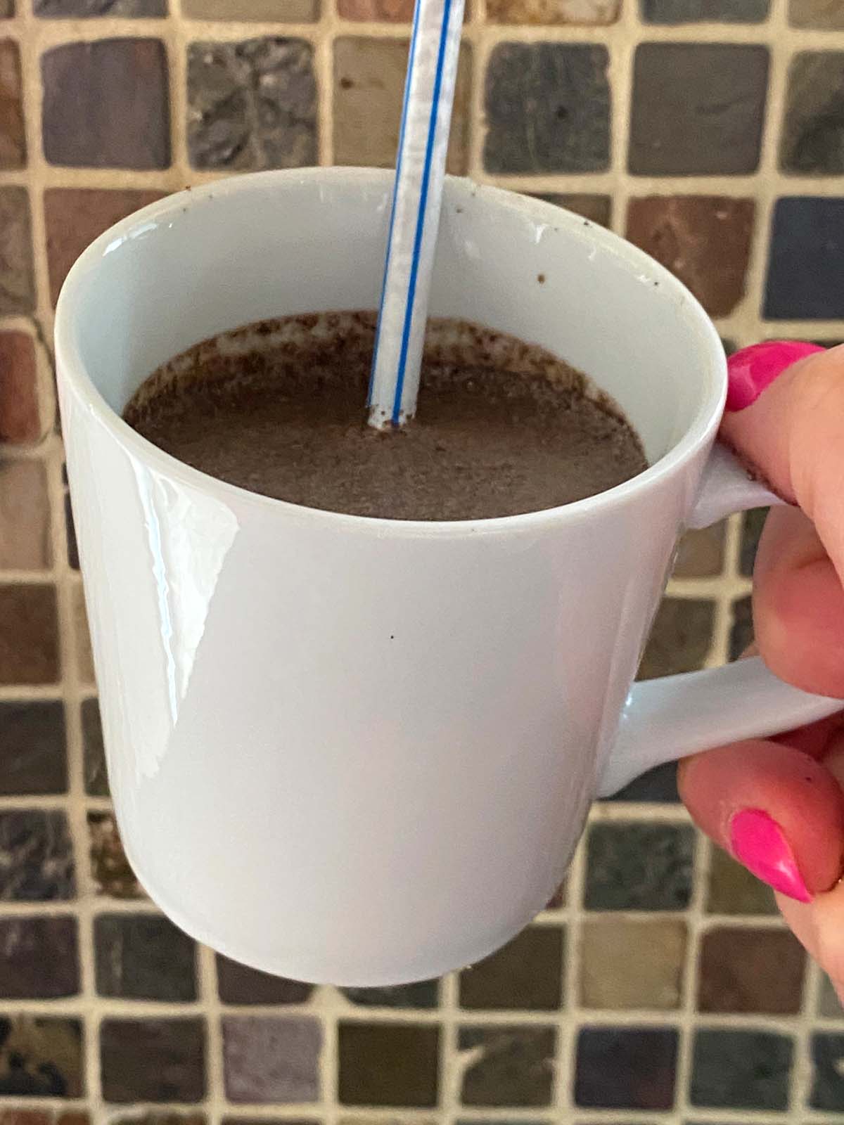Oreo milkshake in a mug with a straw.