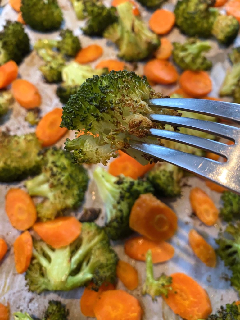 fork holding piece of roasted broccoli