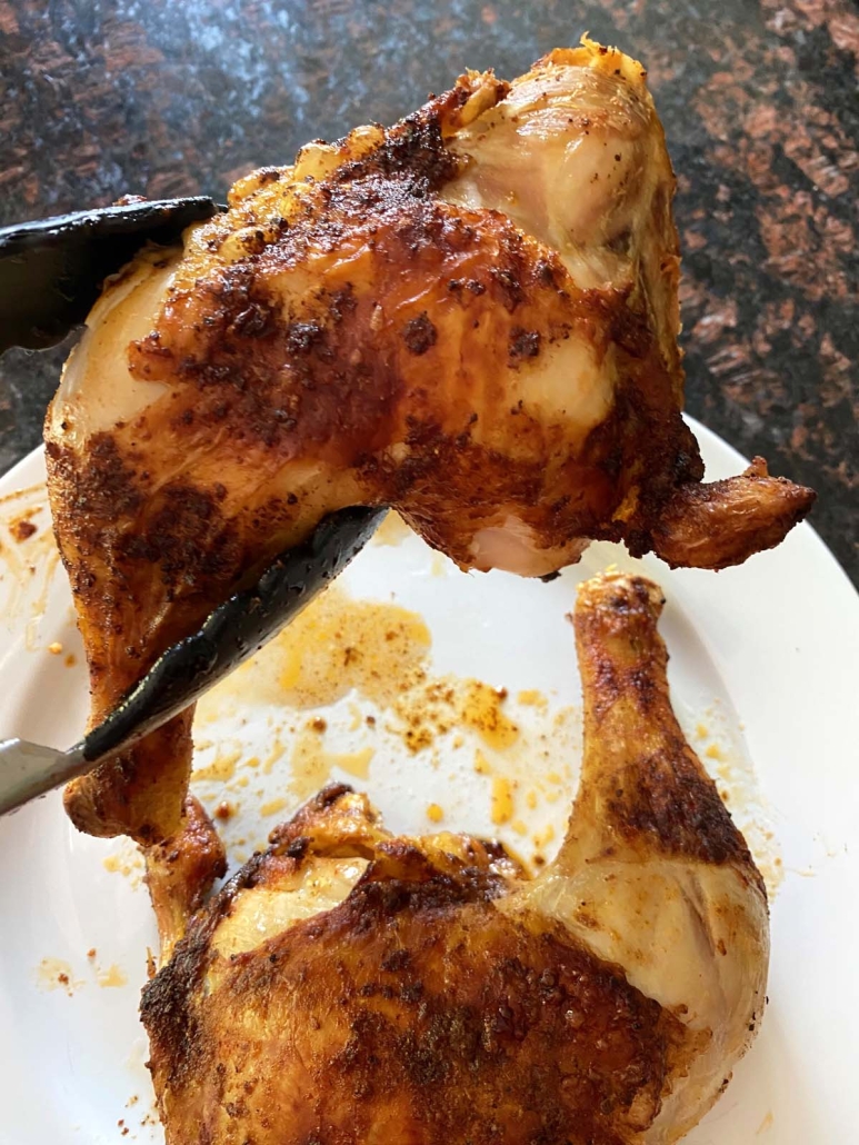 tongs holding Air Fryer Chicken Leg Quarters