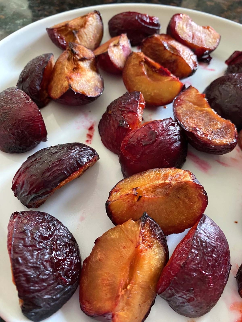 juicy roasted plums on a plate
