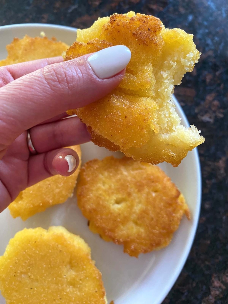 hand holding Hot Water Cornbread with bite in it