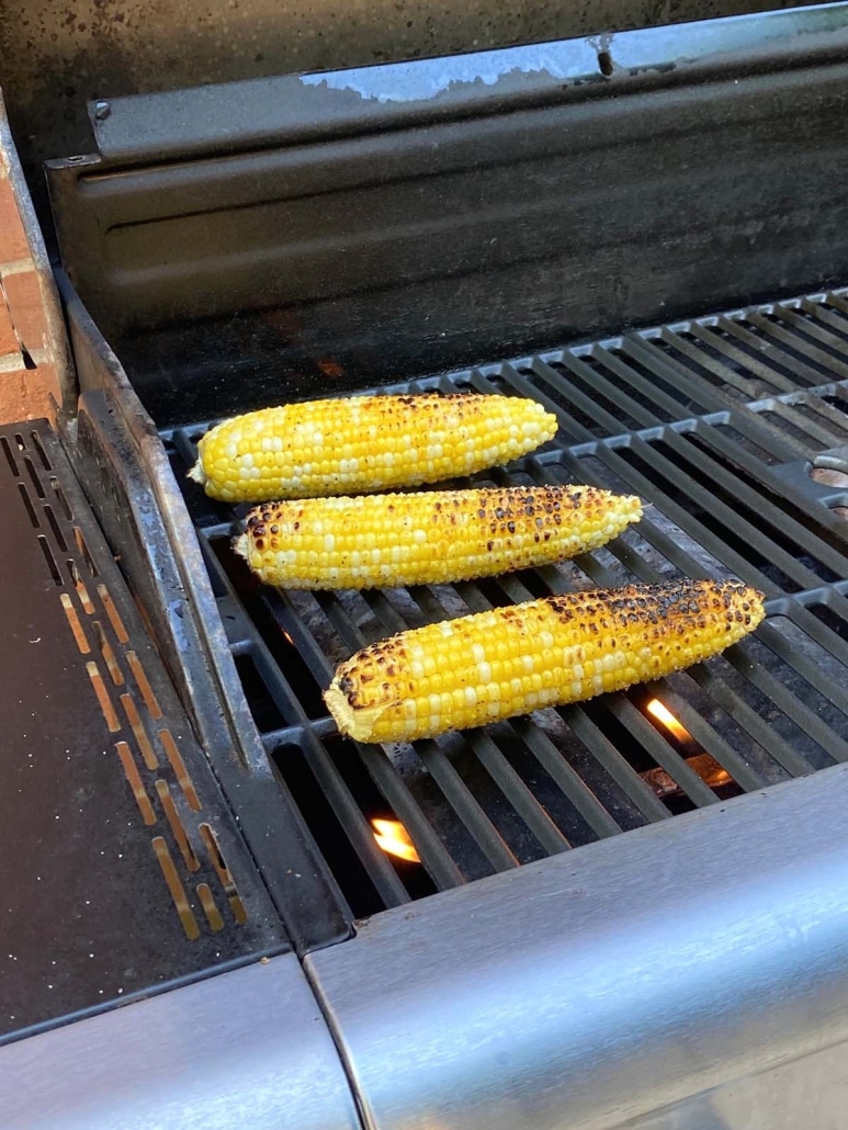 grill opened to show corn cooking 
