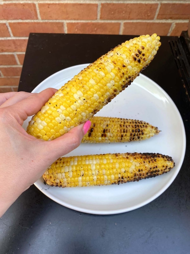 hand holding Grilled Corn On The Cob