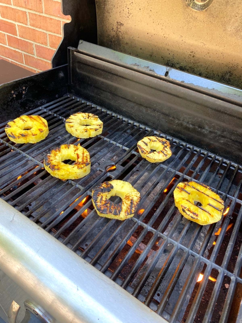 slices of pineapple on the grill