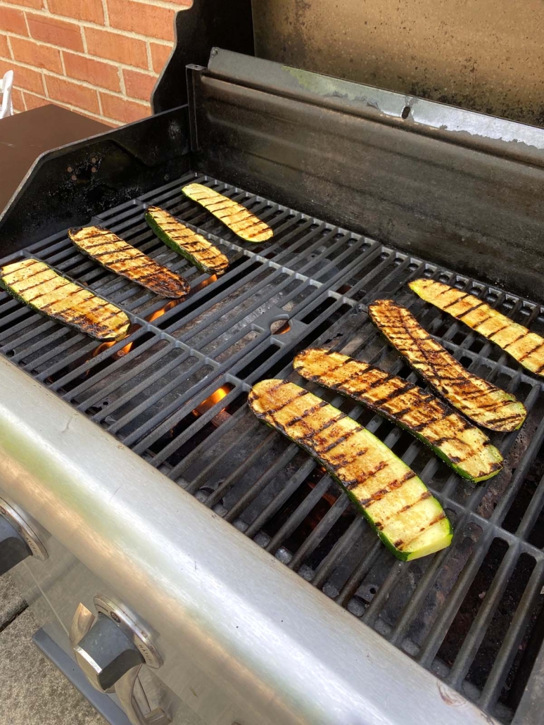 grill opened to show zucchini slices cooking
