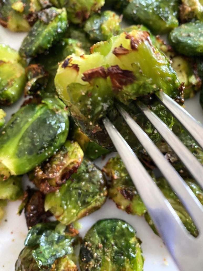 fork holding piece of Smashed Brussels Sprouts roasted in Air Fryer