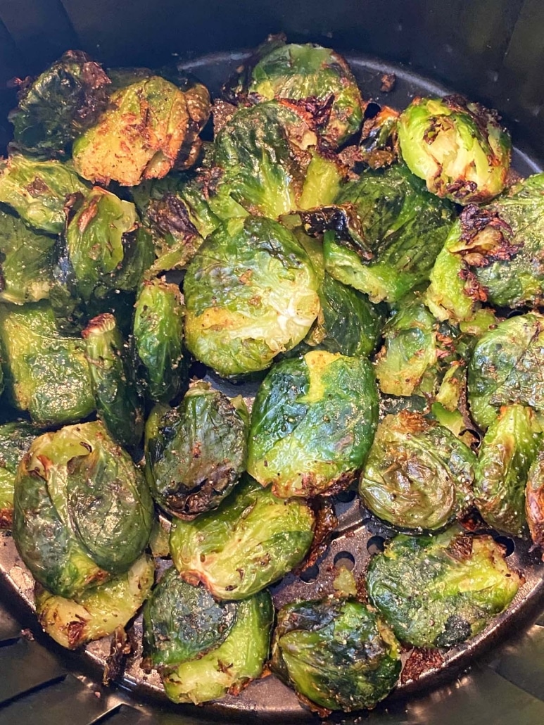 air fryer basket with smashed, seasoned Brussels Sprouts inside