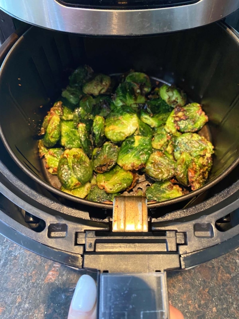 air fryer opened to show Brussels Sprouts roasting inside