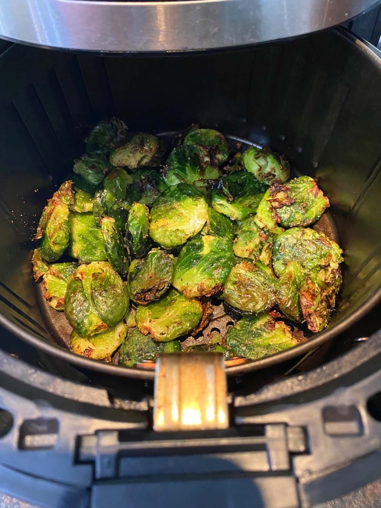air fryer opened to show smashed brussels sprouts inside