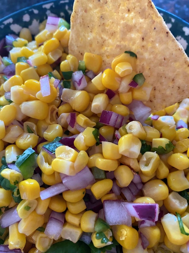 tortilla chip in corn salsa with red onion and jalapeños
