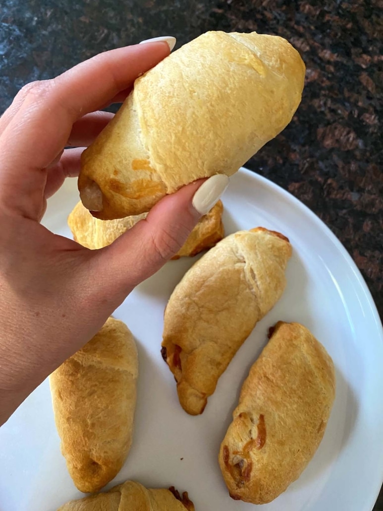 hand holding pizza roll made with crescent dough