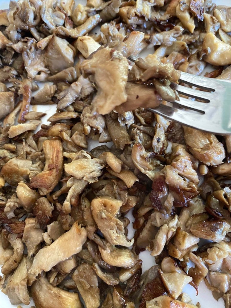 fork with bite of cooked oyster mushrooms
