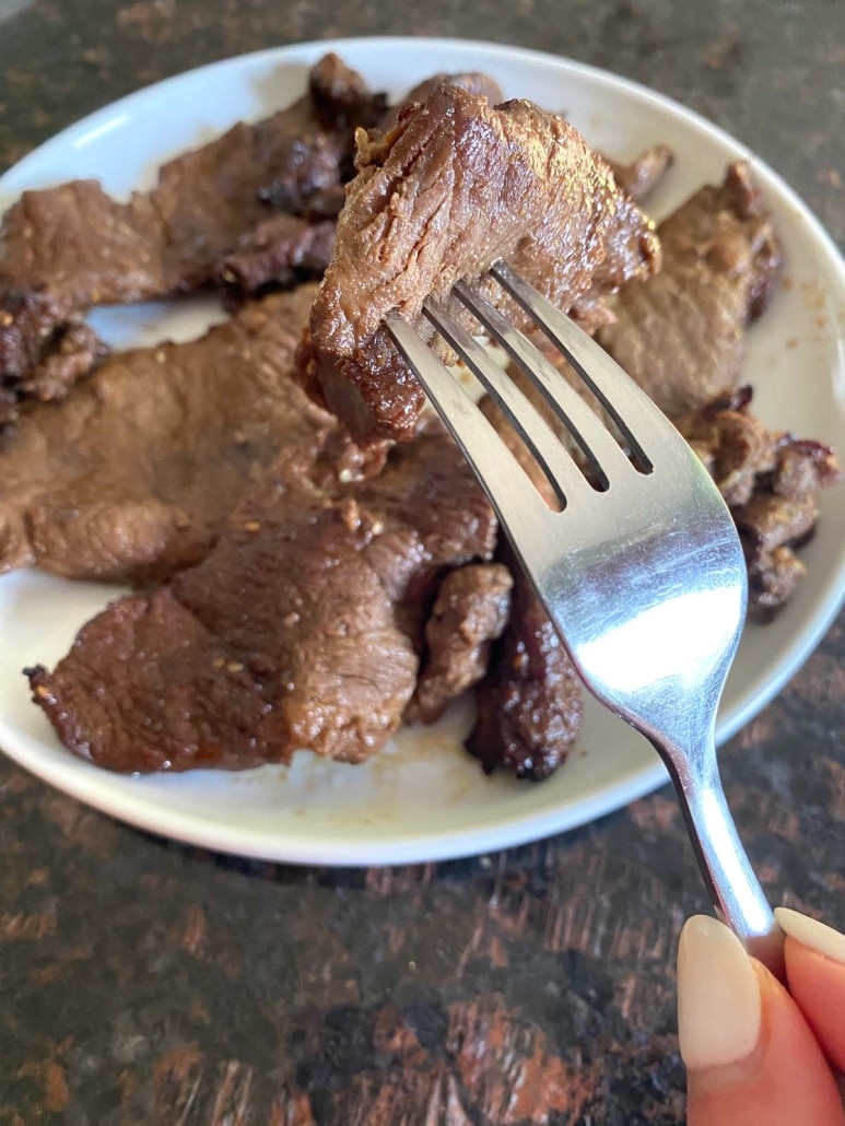 fork holding piece of marinated beef