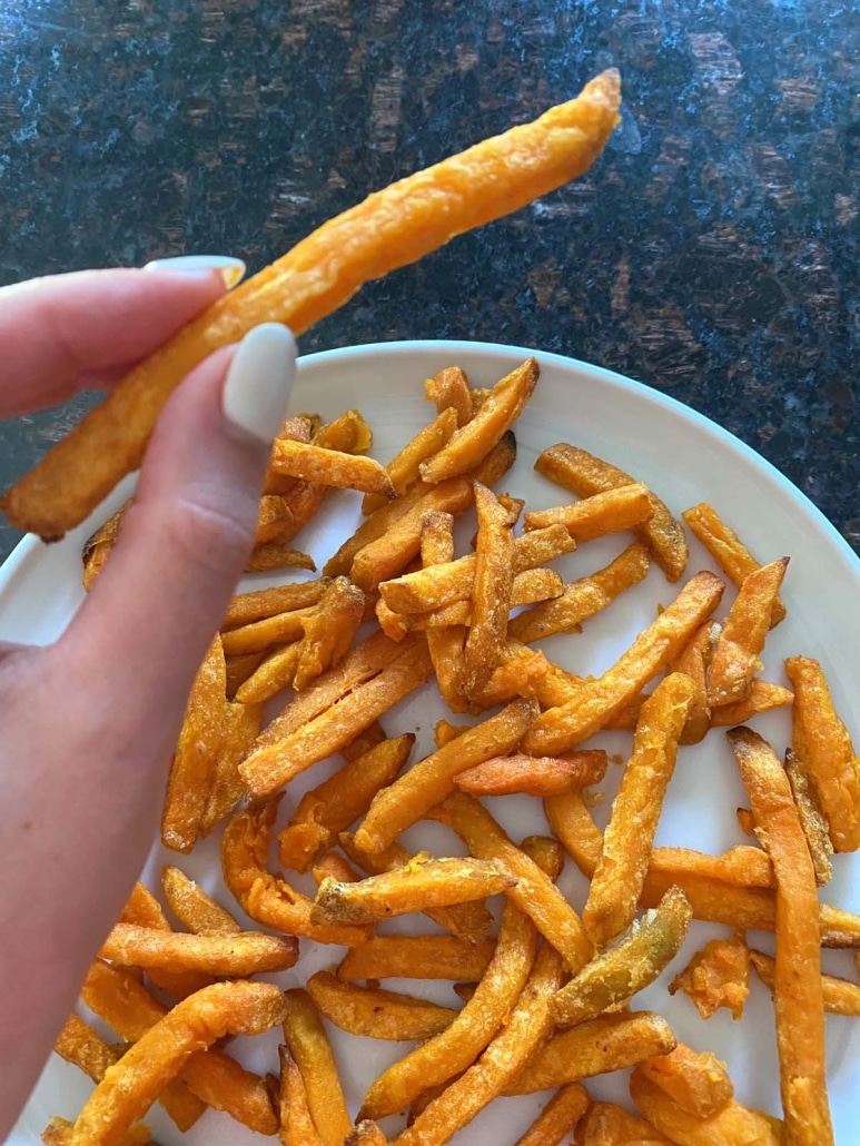 hand holding sweet potato fry from Trader Joe's