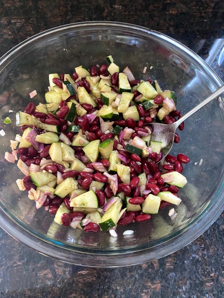 tossing Kidney Bean Salad in salt and pepper seasonings