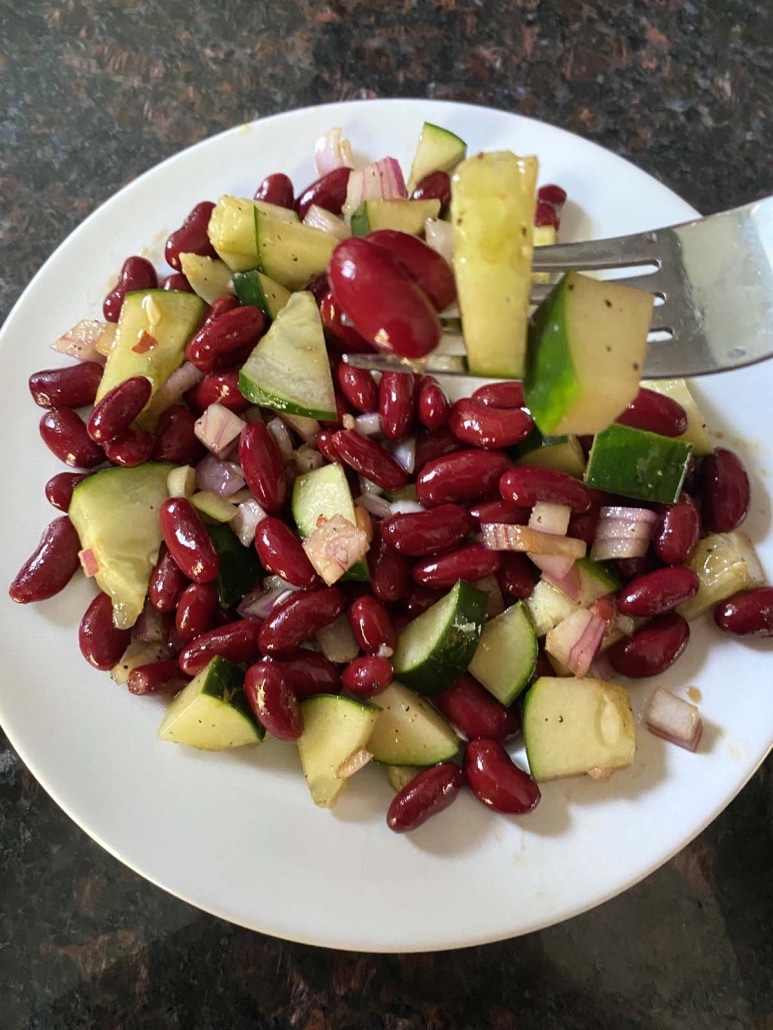 fork with bites of cucumber, red onion, and kidney beans