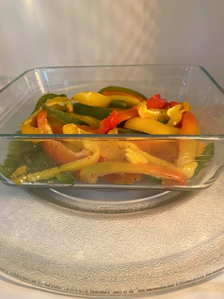 microwave-safe container with cooked bell peppers inside