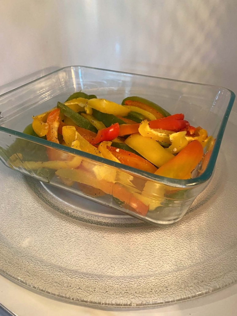 container of cooked bell peppers inside a microwave