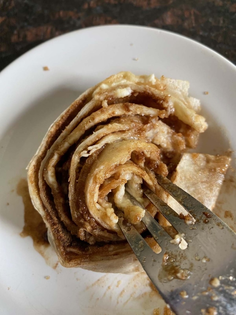 fork breaking up tortilla cinnamon roll