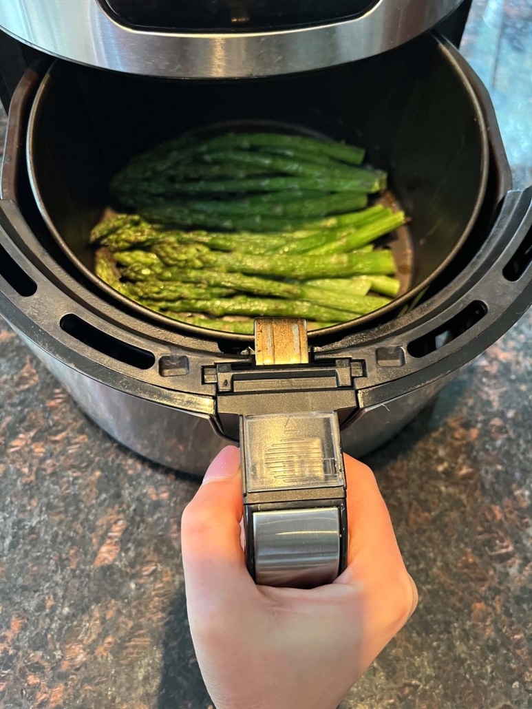 air fryer opened to show healthy side dish Frozen Asparagus cooking inside