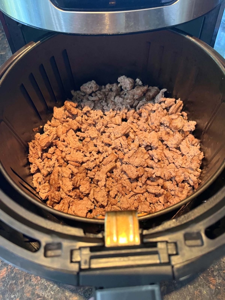 air fryer opened to show crumbled ground turkey inside