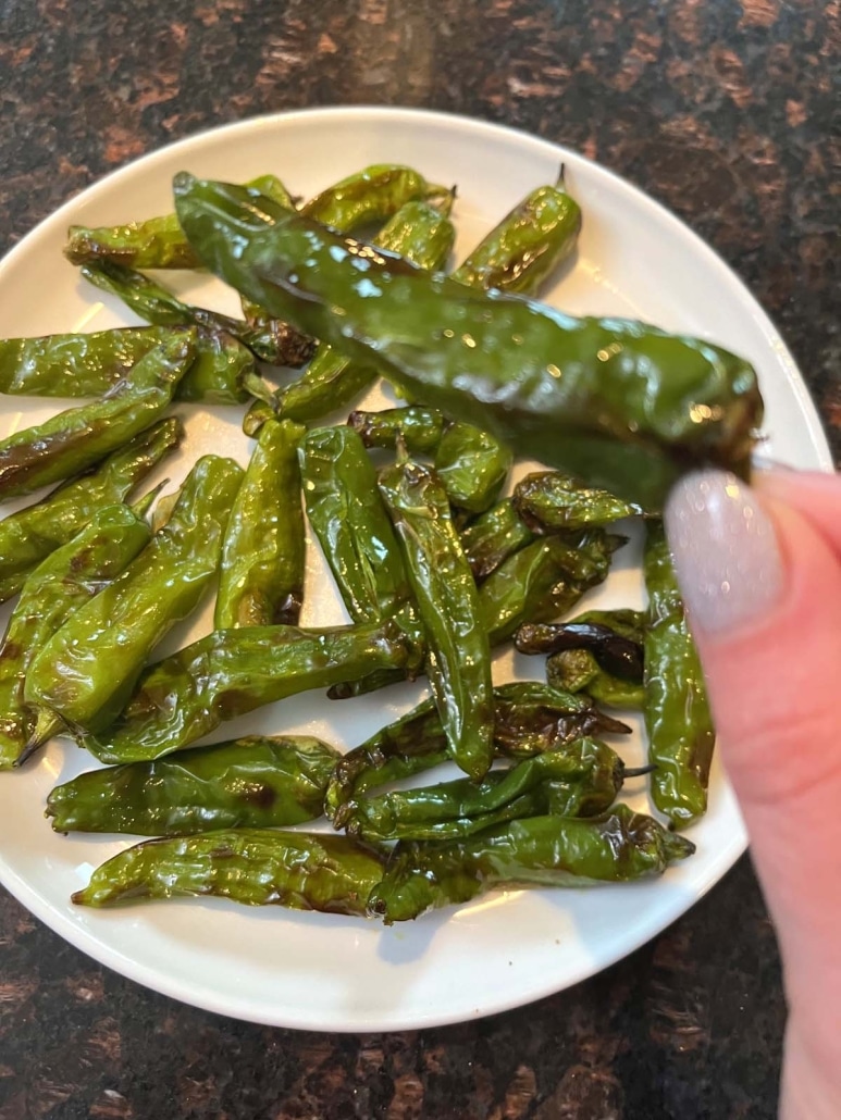 hand holding cooked shishito pepper