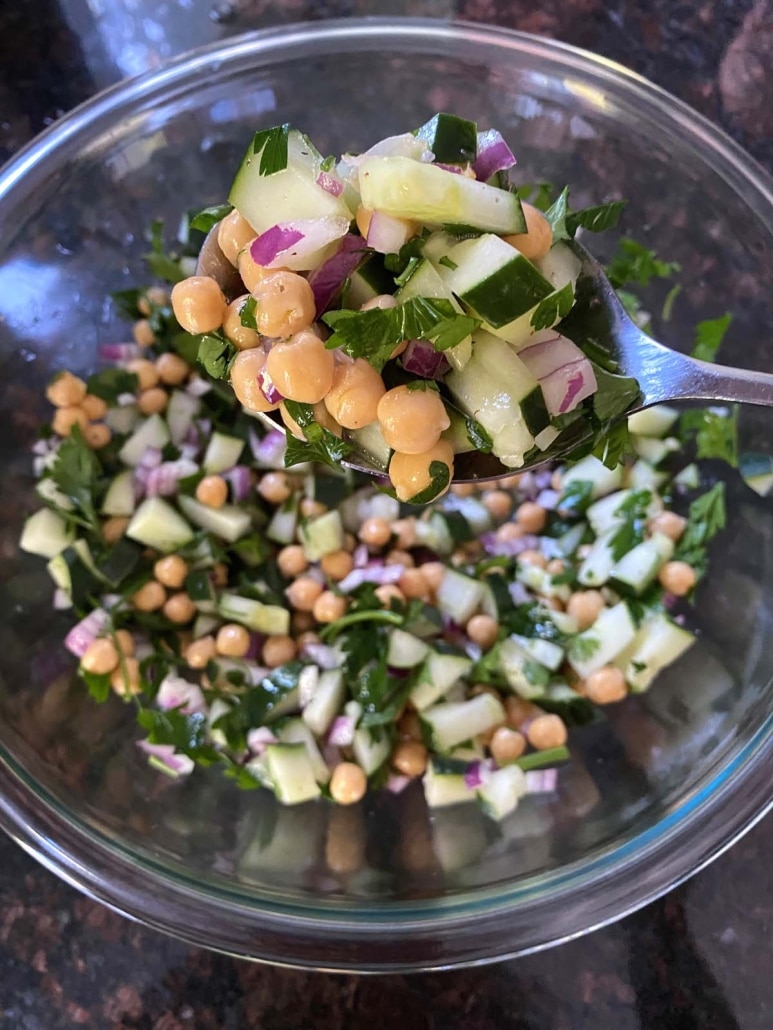 spoon mixing up Cucumber Chickpea Salad