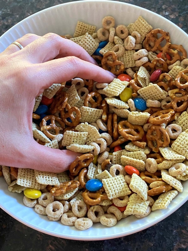 hand grabbing some delicious Homemade Chex Mix