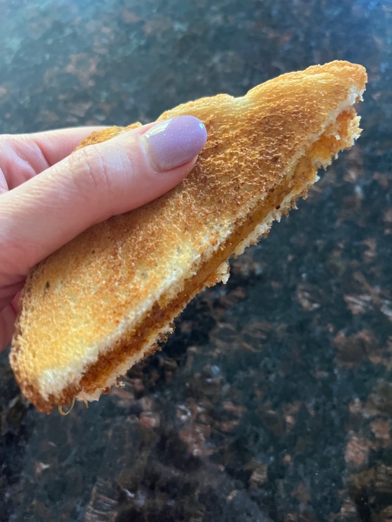 hand holding Microwave Grilled Cheese with sharp cheddar cheese