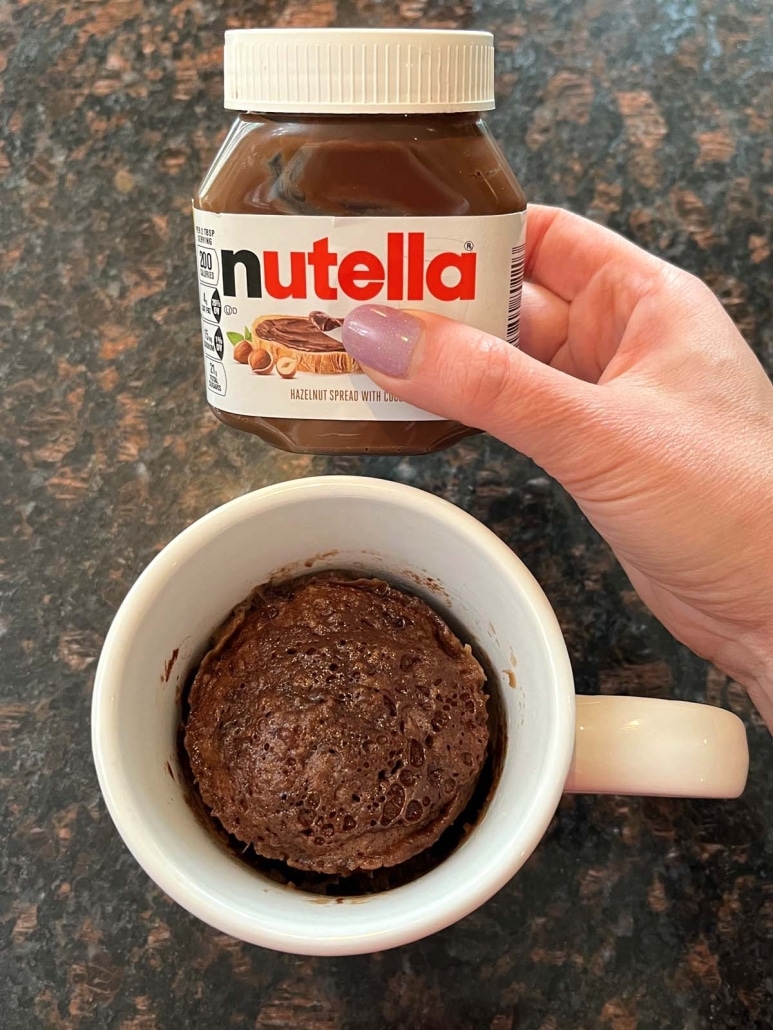 hand holding jar of Nutella next to Nutella Mug Cake