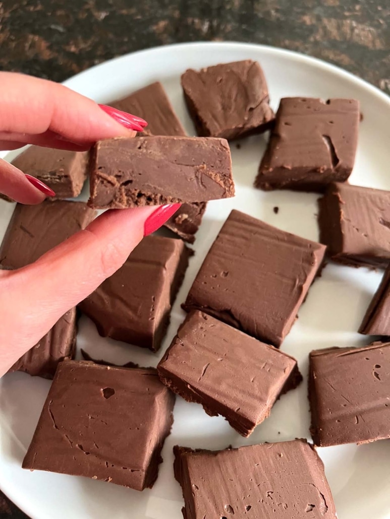 hand holding piece of microwave fudge