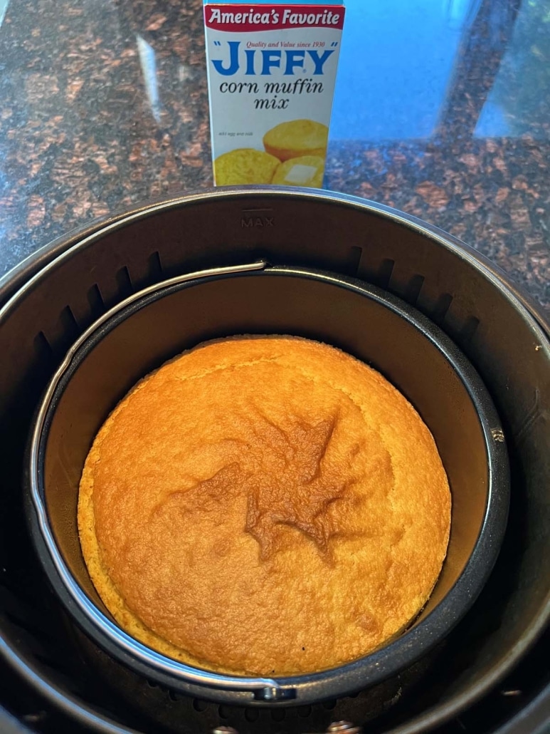 cornbread in an air fryer pan next to a package of Jiffy corn muffin mix