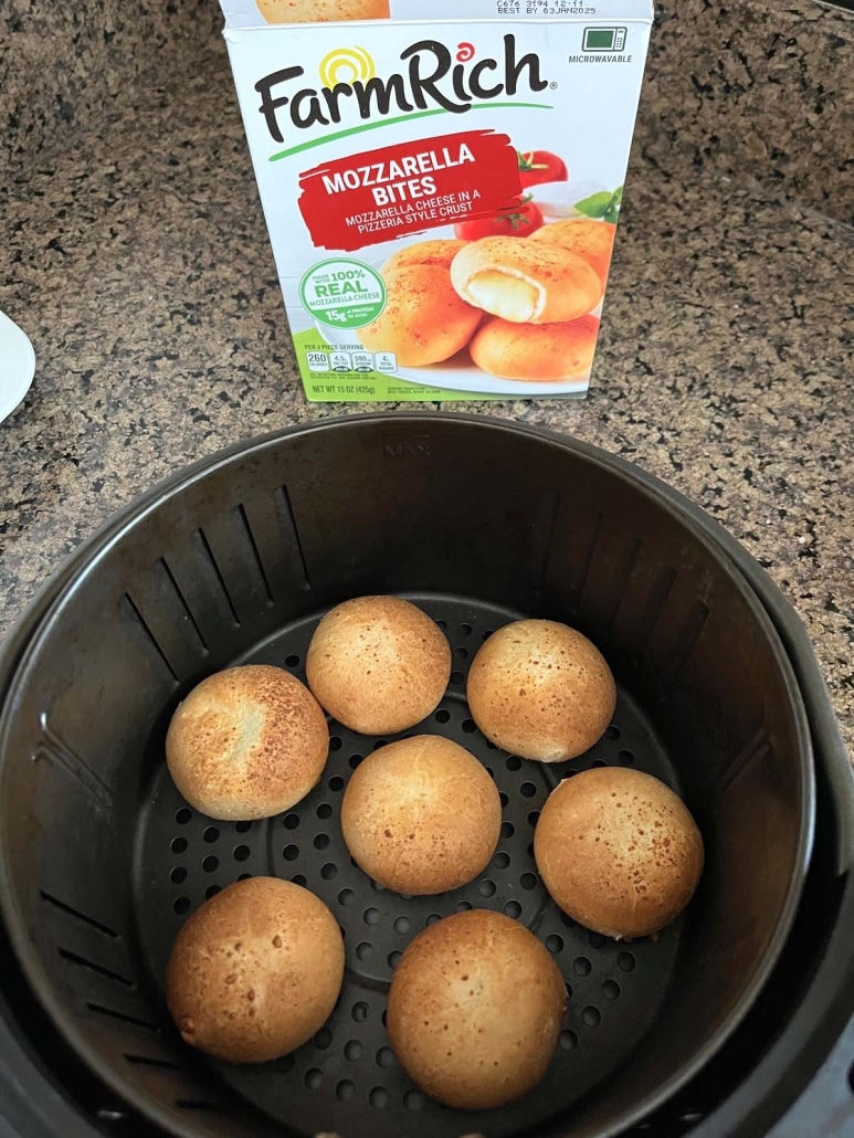 package of frozen mozzarella bites next to an air fryer basket with cooked mozzarella bites inside